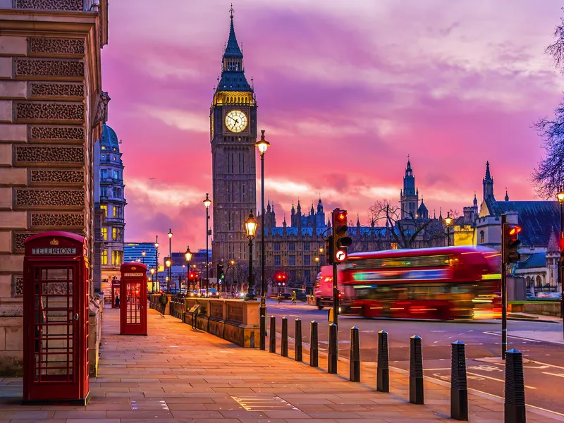 Big Ben und ein roter Bus bei Sonnenuntergang in London.