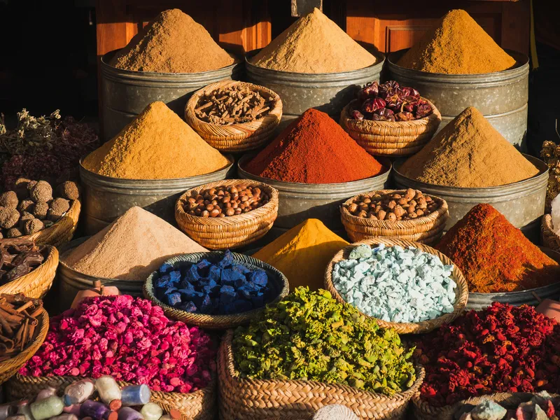 Bunte Gewürze auf einem traditionellen Marktstand in der Medina von Marrakesch, Marokko.