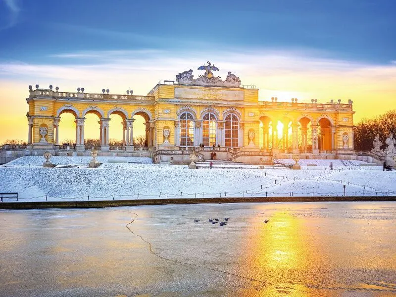 Ein winterlicher Sonnenuntergang hinter der Gloriette in Schönbrunn, Wien.