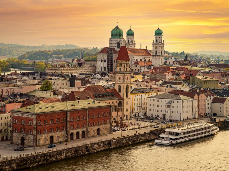 Stadtansicht von Passau mit Donau und Dom bei Sonnenuntergang.