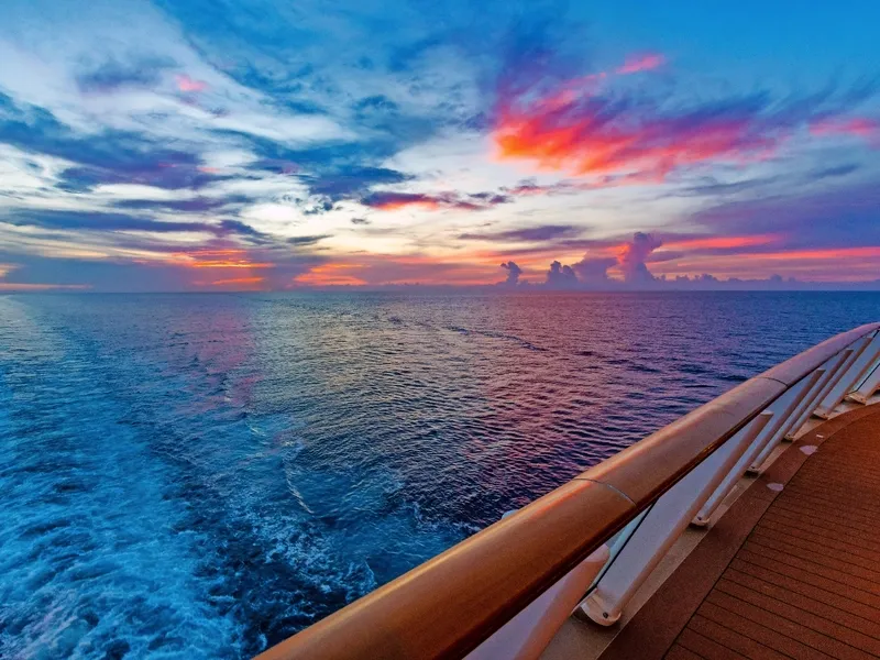 Sonnenuntergang über dem Meer von einem Schiffsdeck aus gesehen.
