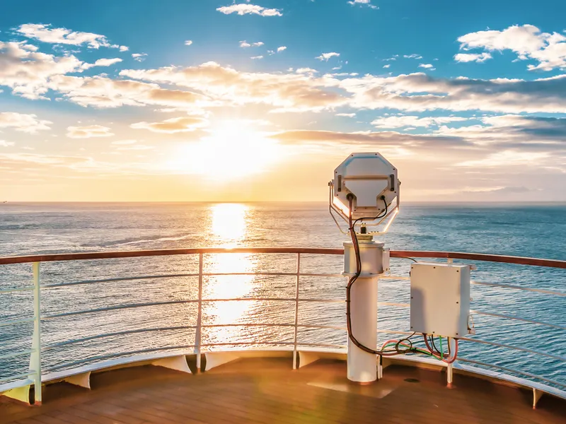 Aussicht von einem Kreuzfahrtschiff bei Sonnenuntergang auf das Meer.