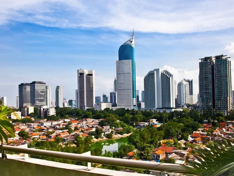 Stadtpanorama mit modernen Wolkenkratzern und kleineren Gebäuden im Vordergrund.