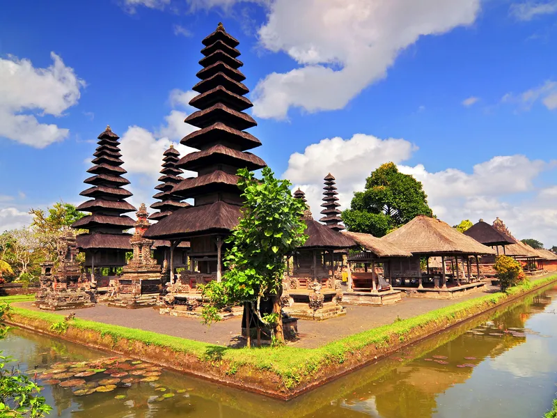 Hindu-Tempel mit Pagodendächern in tropischer Landschaft bei blauem Himmel