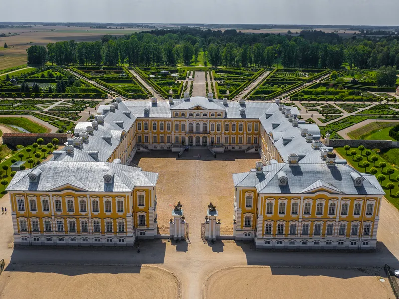 Luftaufnahme eines prächtigen, barocken Schlosses mit weitläufigem Garten.