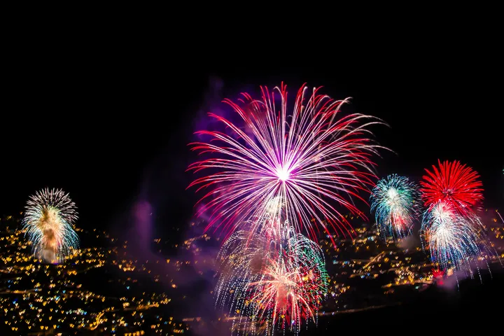 ©Marc - stock.adobe.com Ein Feuerwerk erleuchtet den Nachthimmel über einer Stadt.