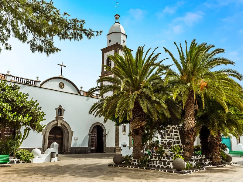 Plaza de las Palmas in Arrecife auf Lanzarote mit Kirchengebäude und Palmen im Vordergrund.