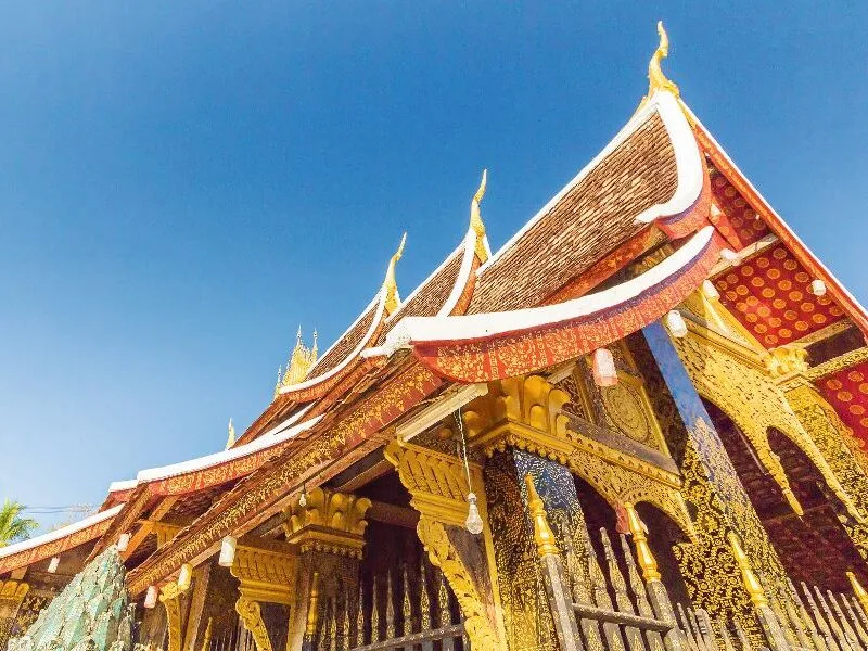 Buddhistischer Tempel mit reich verziertem Dach vor blauem Himmel