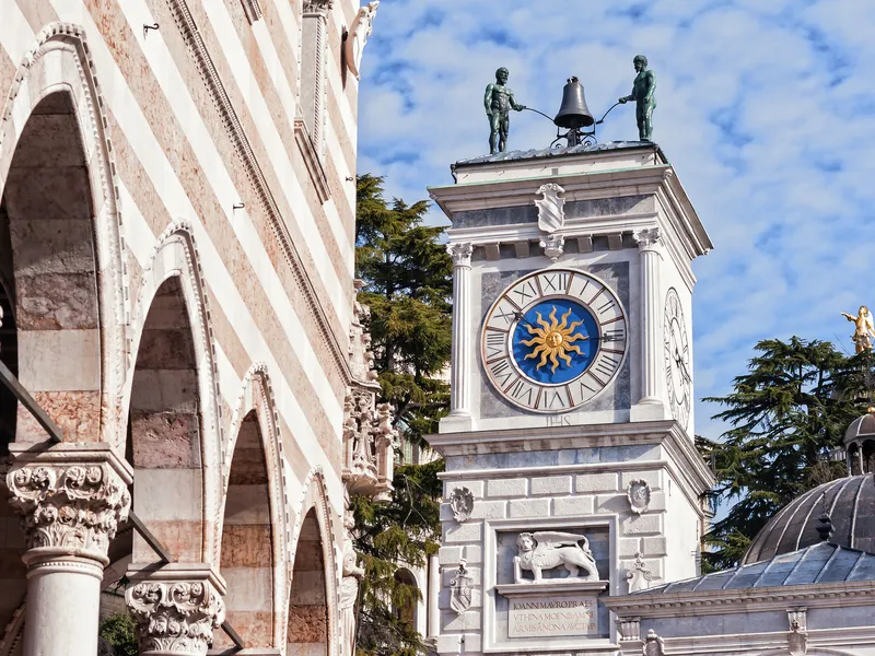Uhrturm der Loggia di San Giovanni und Statue des Herkules in Udine, Italien.