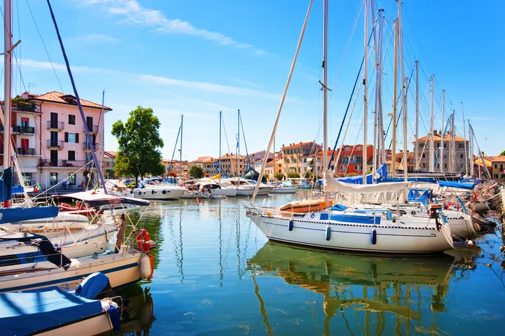 © JFL Photography - stock.adobe.com Jachthafen mit Segelbooten und bunten Gebäuden im Hintergrund bei klarem Wetter.