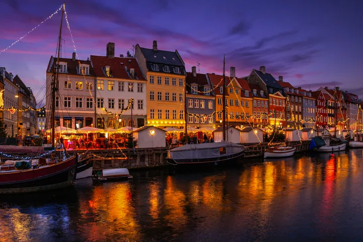 © moofushi - stock.adobe.com Abendstimmung mit beleuchteten Häusern und Booten an einem Kanal.