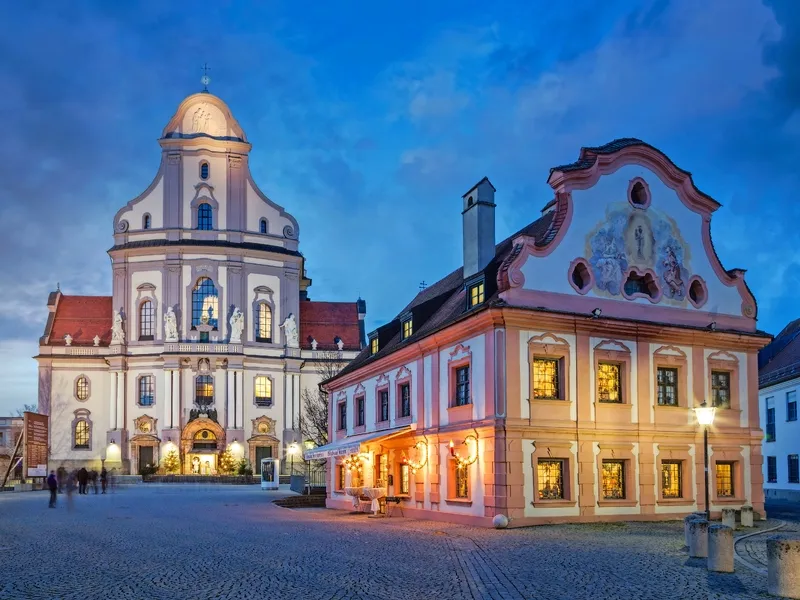 Historische Gebäude am Abend in einem beleuchteten Stadtplatz.