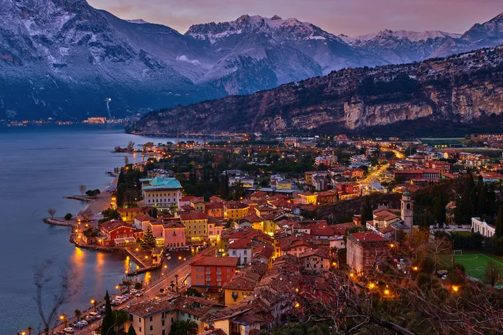 © DannyIacob - stock.adobe.com Stadt und See vor einer Bergkulisse bei Sonnenuntergang.