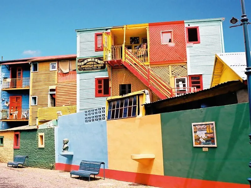 Bunte Fassaden von Gebäuden in La Boca, einem lebhaften Viertel von Buenos Aires, Argentinien. Helle Farben und vielfältige architektonische Details prägen das Bild.