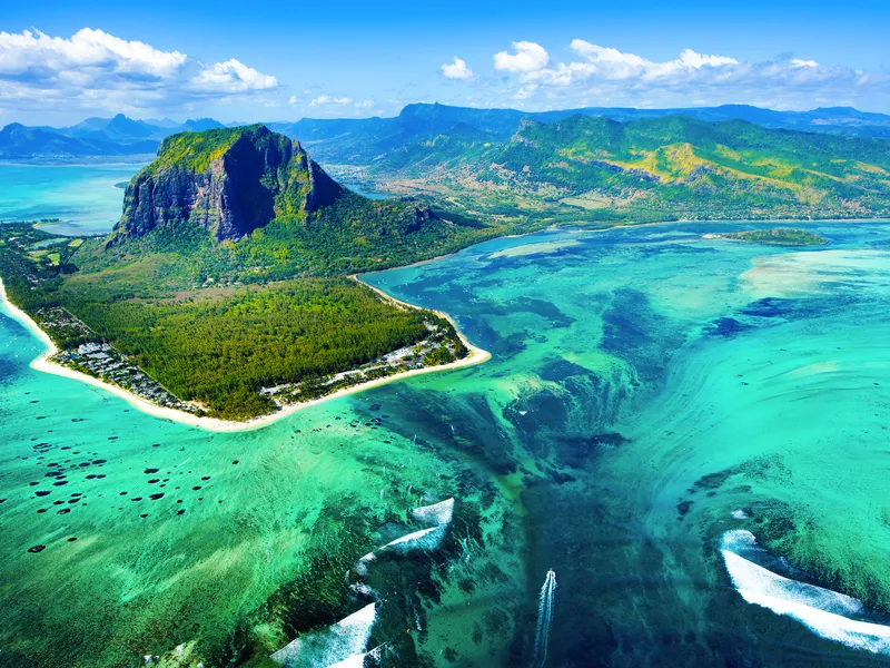 Luftaufnahme einer tropischen Insel mit Strand und türkisfarbenem Meer.