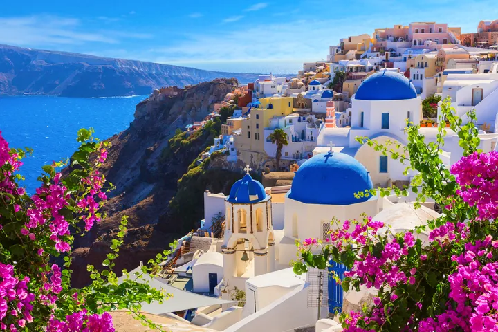 Griechisches Dorf mit blauen Kuppeln und Blick auf das Meer.
