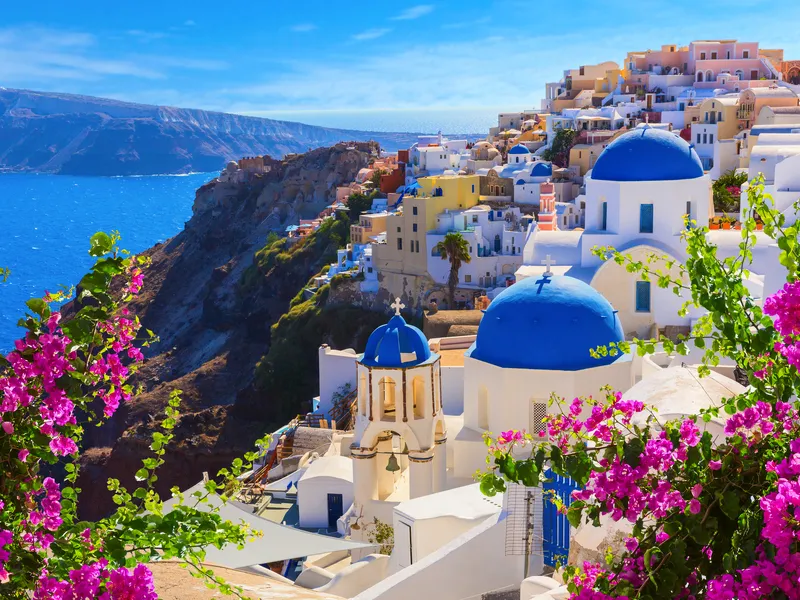 Griechisches Dorf mit blauen Kuppeln und Blick auf das Meer.