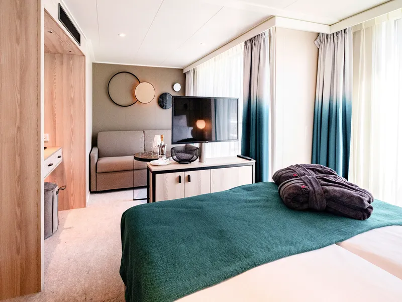 Moderne Kabine mit Bett, Sofa, TV und Dekorationselementen.